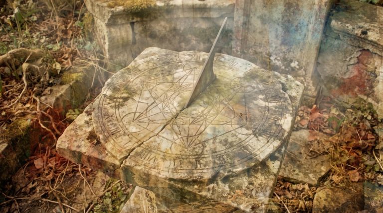 Peur du temps qui passe : un cadran solaire de pierre ancien, usé, aux motifs gravés