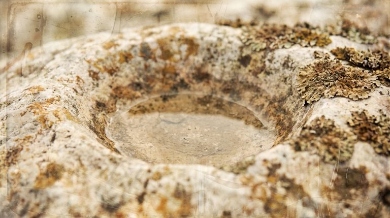 Sentiment de vide intérieur : un creux usé dans une pierre pâle, gagnée par le lichen