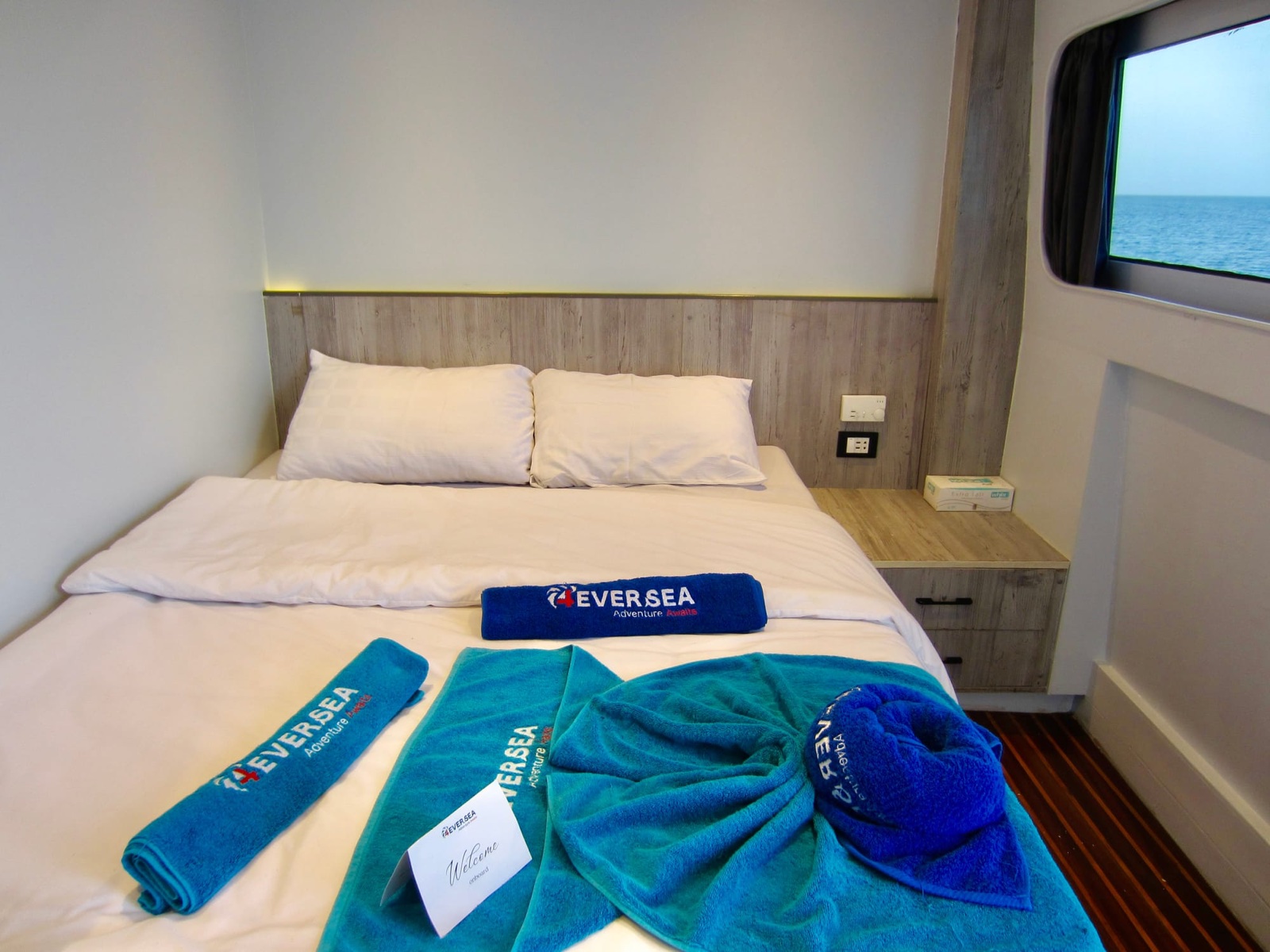 Une cabine double avec grand lit et hublot sur la mer